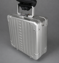 Aluminium personal item flight case being carried by hand to demonstrate its size and portability.