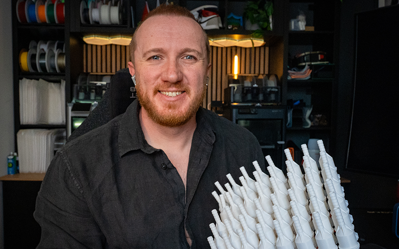 Axel Brown holding custom-designed tumble dryer waste pipe adapters developed and manufactured by Axe Design.