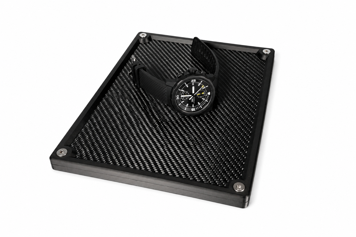 Large carbon fibre organiser tray storing everyday carry essentials on a desk.